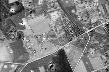 Luftaufnahme der schweren Flak-Stellung "Wellmann" im Osnabrücker Stadtteil Schinkel aus dem Jahr 1945. Neben der Stellung ist der Schinkeler Friedhof zu sehen. Quer durchs Bild verläuft die Belmer Straße. Luftaufnahme Flak-Stellung Wellmann Schinkel 1945