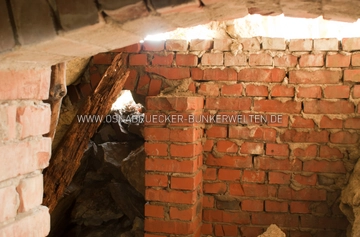 Blick aus dem Stollen durch die ehemalige Schleuse. Die Durchgänge waren versetzt angelegt worden, um einen möglichen Splitterflug ins Innere der Anlage weitestgehend zu verhindern. Schleuse Luftschutzstollen Sentrup