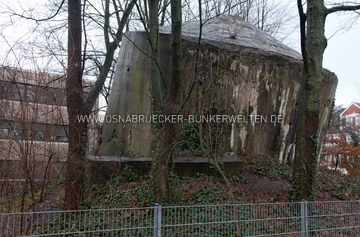Der Kleinhochbunker am Hoffmeyerplatz in Osnabrück. Am Fuß des Bunkers ist im Erdwall einer der zwei ehemaligen Eingangsbauwerke zu erkennen. Kleinhochbunker Hoffmeyerplatz Osnabrück