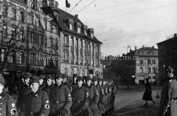 Eine Abteilung des R.A.D. auf dem Adolf-Hitler-Platz (heute Neumarkt) in Osnabrück. Auf der Rückseite wurde notiert: "Am 30. Januar 1938 in Osnabrück / Auf dem Weg zur Kundgebung / x Am. Beier" RAD Marsch auf Adolf-Hitler-Platz (heute Neumarkt) in Osnabrück