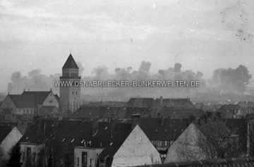 Rauchschwaden über dem Fledder am 13.9.1944. Im Vordergrund ist allem Anschein nach das Haus Hauswörmannsweg Nr. 33 - 35 zu sehen. Rechts daneben Schürenstraße 8. Im Hintergrund die St. Joseph-Kirche. Das Gebäude, dessen Dach man im Vordergrund erkennt, scheint nicht mehr zu existieren. Rauchschwaden über Osnabrück, 13.9.1944