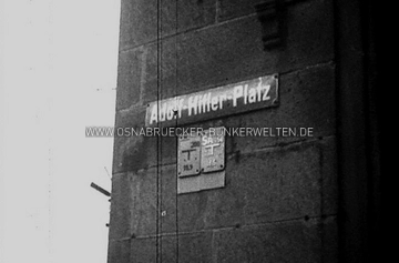 Straßenschild mit der Aufschrift "Adolf-Hitler-Platz" am heutigen Neumarkt in Osnabrück. Der Fassade nach zu urteilen könnte das Schild am Gerichtsgebäude angebracht gewesen sein. Straßenschild "Adolf-Hitler-Platz" in Osnabrück