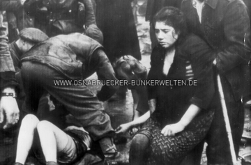 Britische Soldaten leisten ehemaligen russischen Zwangsarbeiterinnen erste Hilfe, nachdem diese aus einem brennenden Keller gerettet wurden. Auf der Rückseite des Fotos wurde vermerkt: "4/8;45 British troops treat former Russian "Slave Laborers" after rescuing them from a burning store basement in Osnabrueck, Germany. After their liberation, the Russians entered a bombed store basement to recover clothing. They were observed by a German policeman who set fire to the place. Two of them died. British official photo. / AP WIREPHOTO / GERMANY" Britische Soldaten leisten Erste Hilfe in Osnabrück 1945
