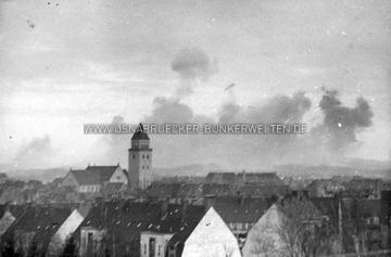 Erste Rauchschwaden steigen am 13.09.1944 über Osnabrück auf. In der Bildmitte ist die St. Joseph-Kirche zu erkennen. Im Vordergrund Häuser am Hauswörmannsweg. Rauchschwaden über Osnabrück, 13.09.1944