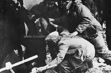 Britische Soldaten retten eine russische Frau aus einem brennenden Keller im April 1945. Auf der Rückseite des Fotos wurde vermerkt: "RADIOPHOTO ROB 756160 ... NEW YORK BUREAU / Pulled to safety / Germany -- British soldiers rescue a Russian woman from a bombed-out store which a Nazi policeman, still on duty, deliberately fired. Russians, former slave-laborers freed by British at Osnabruck, entered the store to recover clothing. Two died in blaze startet by the Nazi; the rest recovered after treatment. / BU SPEC #IA MGS CAN / CREDIT (British official Radiophoto from ACME) 4-8-45" Am Fuß der Rückseite ist noch ein Stempel der Cleveland Press mit dem Datum "Apr 12 1945" zu erkennen. Britische Soldaten retten russische Frau aus brennendem Keller