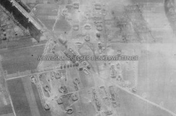 Die Flak-Stellung Sonnenhügel aus der Luft. Zum Zeitpunkt der Aufnahme war die Stellung bereits verwaist. Am unteren Bildrand ist der Falkenweg zu sehen, von oben links nach unten rechts durchzieht die Straße "Am Vogelsang" das Bild. Luftaufnahme Osnabrück-Sonnenhügel, April 1945