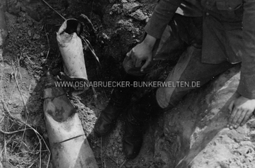 Der freigelegte Blindgänger. Unter dem Foto wurde vermerkt: "Freigelegt erscheint die Bombe dem Oberfeldwebel schon etwas sympathischer. / Aufn.: Kiefer Freigelegter Blindgänger Wiegmann Technische Nothilfe Osnabrück