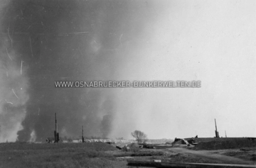 Ein Foto aus der Flak-Stellung am Sonnenhügel, augenommen nach dem schweren Luftangriff vom 13.5.1944. Im Hintergrund sind die Rauchschwaden der brennenden Innenstadt zu sehen. Auf der Rückseite des Fotos wurde notiert: "Das brennende Osnabrück nach dem Angriff vom 13.5.44" Flak-Stellung Sonnenhügel 13.5.1944