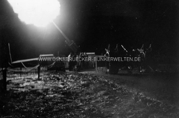 Bildunterschrift: "Mündungsfeuer der schweren Flak. Durch das Mündungsfeuer wird die Stellung taghell erleuchtet." Im Vordergrund rechts ist ein Teil eines Sonderanhängers 201 zu erkennen. Flakfeuer Westerberg 1940