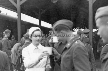 Versorgung von Luftwaffenangehörigen, angeblich aufgenommen am Hauptbahnhof Osnabrück. Aufgrund der hölzernen Stützpfosten der Bahnsteigüberdachung bestehen jedoch Zweifel an der Richtigkeit dieser Information. Wann genau die Aufnahme entstand, wurde zudem leider nicht vermerkt. Krankenschwester Luftwaffenangehörige Osnabrück Hauptbahnhof