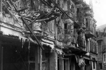Die Osnabrücker Krahnstraße nach dem verheerenden Luftangriff vom 6.10.1942. Zu sehen sind die Häuser 33 - 36 (von rechts nach links), Blickrichtung Nikolaiort. Auf der Rückseite wurde notiert: "1. Luftangriff auf Osnabrück am 6.10.1942 / 2. Sprengbombe. / 3. Getroffen wurden die Wohn= und Geschäftshäuser Krahnstr. 15, 16, 17/18, 19, 20, 21, 22, 34, 35, 38, 39, 41 u. 45. / 4. Die genannten Häuser wurden zerstört." Krahnstraße Osnabrück nach Luftangriff vom 6.10.1942