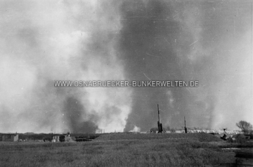 In der Flak-Stellung Sonnenhügel. Das Foto entstand nach dem schweren Luftangriff auf Osnabrück am 13.5.1944. Im Hintergrund sind die Rauchschwaden aus der Innenstadt zu sehen. Auf der Rückseite wurde notiert: "Am 13.5.1944" Flak-Stellung Sonnenhügel 13.5.1944