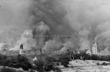 Luftangriff auf Osnabrück am 13. September 1944. Die Aufnahme wurde vom Ziegenbrink aus gemacht. Im Vordergrund sind einige Schaulustige zu erkennen, dahinter die Häuser Bomblatstraße 20-30. Luftangriff auf Osnabrück am 13. September 1944