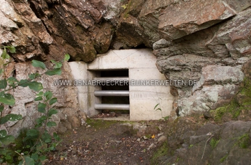 Ein mittlerweile versiegelter Nebenstollen der Anlage Zeolith. Von hier aus verläuft ein Felsengang ca. 5 Meter in den Berg hinein und schließt dort an einen ausgebauten Querstollen an, der in den "Hauptstollen" führt. Mittlerweile versiegelter Nebenstollen der Anlage Zeolith