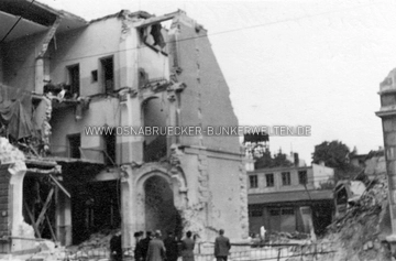 Trümmer des Ostflügels der Hauptpost an der Möserstraße nach dem Bombentreffer vom 20. Juni 1942. Hier befanden sich unter Anderem Büros des Fernsprechamts. Der Schaden wurde noch im Krieg ausgebessert. Rechts am Rand sind die Trümmer des Hauses Möserstraße 21 zu erkennen. Der hölzerne Turm im Hintergrund müsste sich in der Nähe der Klusstraße befunden haben. Bombenschaden bei Hauptpost Osnabrück 20.6.1942