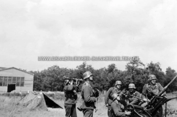Bedienmannschaft an einem 2cm-Flak-Geschütz. Die Aufnahme soll nahe der Klöckner-Werke in Osnabrück aufgenommen worden sein. Allerdings konnte das Gebäude im Hintergrund bisher nicht lokalisiert werden. Leichtes Flak-Geschütz bei Klöckner Osnabrück